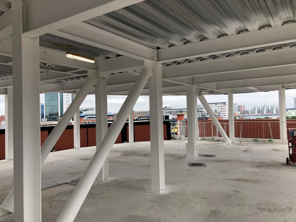 White intumescent-coated steel columns and beams beneath a car park deck